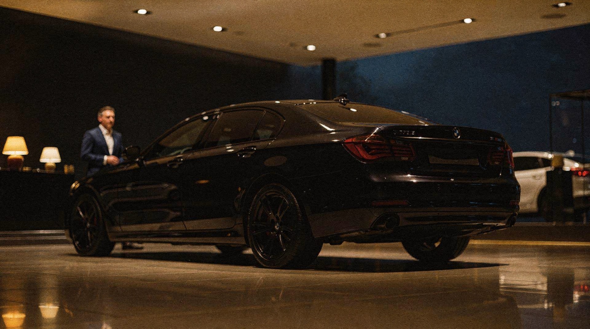 Schwarze Limousine im dunklen Showroom bei Nacht